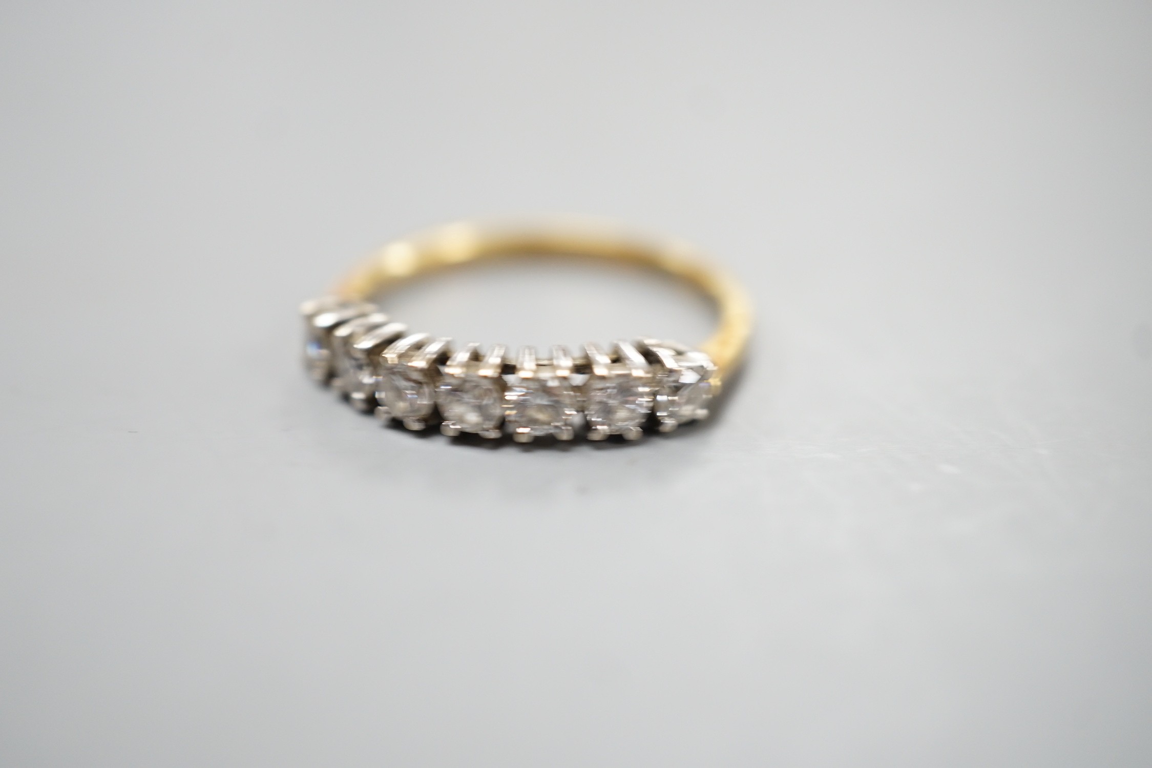 An 18ct gold and seven stone diamond set half hoop ring, size K, gross weight 1.8 grams.